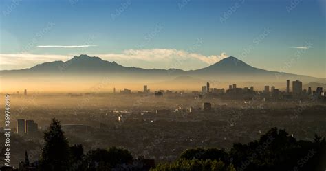 Panoramic view of Mexico City at dawn, with fumarole of active volcano ...