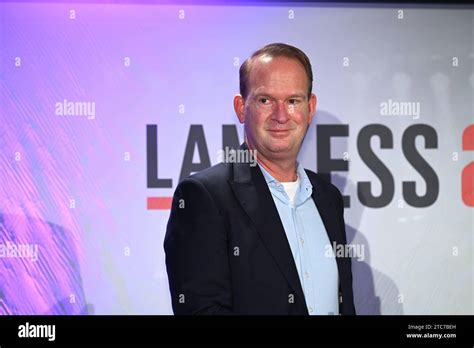 Geschäftsführer der LanxessArena Stefan Löcher vor dem Logo Schriftzug