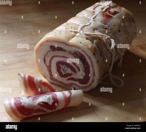 Pancetta Roll And Slices On A Wooden Butcher Block Stock Photo Alamy