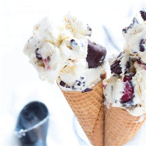 Three Ice Cream Cones With Chocolate And Raspberries In Them On A White Surface