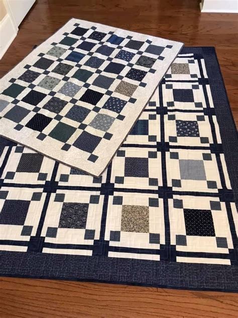 Two Black And White Quilts Sitting On Top Of A Wooden Floor