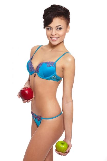 Retrato da bela mulher morena sorridente em lingerie branca dieta de maçã verde e vermelha