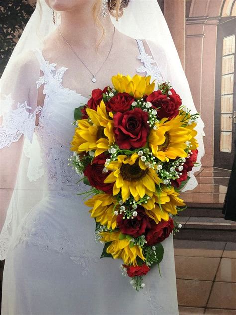 A Bride Holding A Bouquet Of Sunflowers And Red Roses On Her Wedding Day