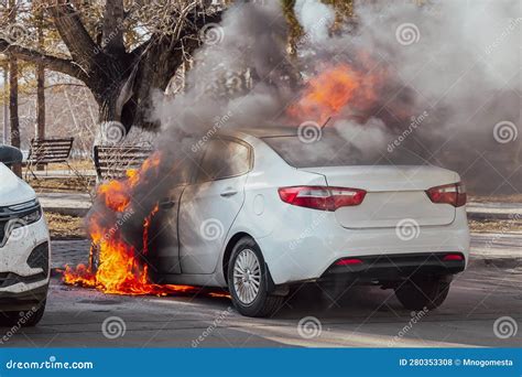 Burning Car Fire Of A White Passenger Car In A City Parking Lot Stock