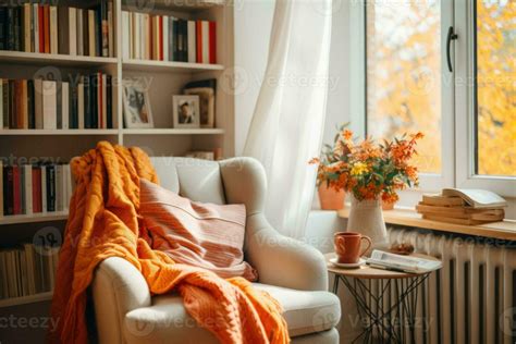 A reading nook complete with an armchair, blanket and a bookshelves ...