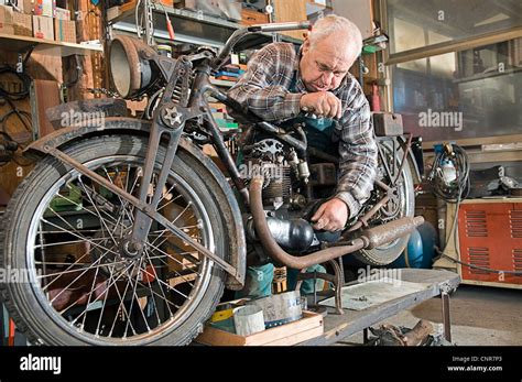 Man Repairing A Vintage Motorbike In His Workshop Stock Photo Alamy