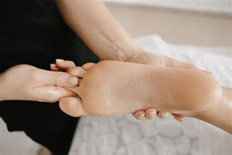 Premium Photo Masseur Doing A Foot Massage With Candles On Background