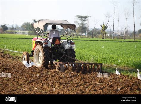 Farmer Ploughing A Field With Tractor Stock Photo Alamy