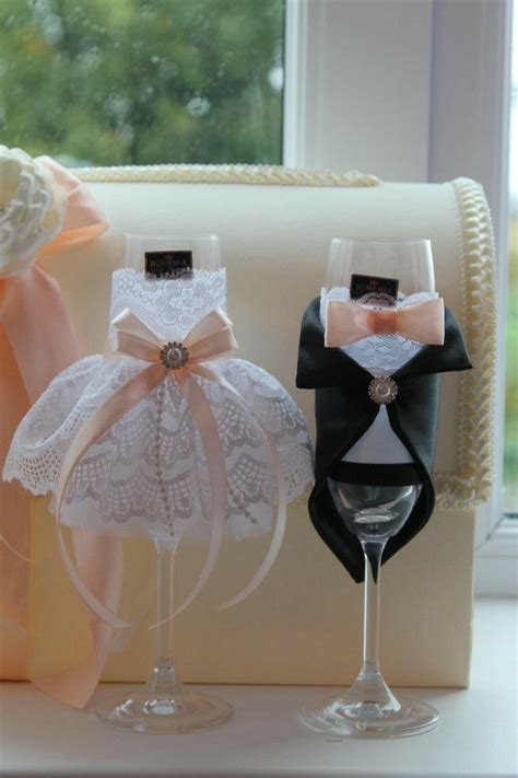 Two Wine Glasses Are Sitting Next To Each Other On A Window Sill With Bows