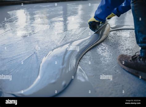 The Worker Applies Gray Epoxy Resin To The New Floor Stock Photo Alamy