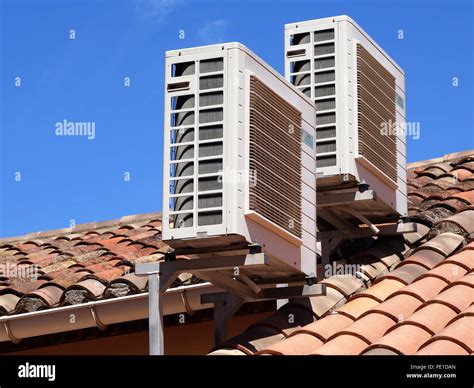 Two Roof Mounted Air Conditioning Units On A House Roof In Cessenon Sur