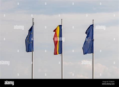 Romanian flag, EU flag and NATO flag against a cloudy sky, at the ...