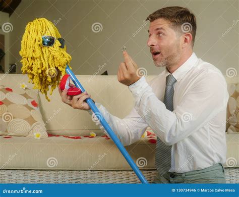 Funny Portrait Of Young Weird Crazy And Happy Man Holding Mop With