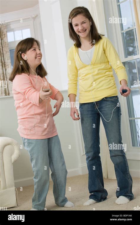 Two Teenage Girls Listening To Mp3 Players Stock Photo Alamy