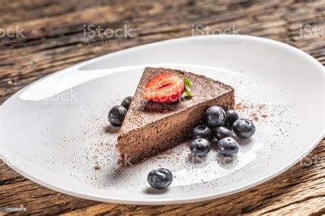 Potongan Segitiga Kue Mousse Cokelat Dengan Blueberry Dan Stroberi Foto