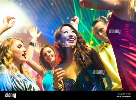 Group Of Party People Men And Women Dancing In A Disco Club To The