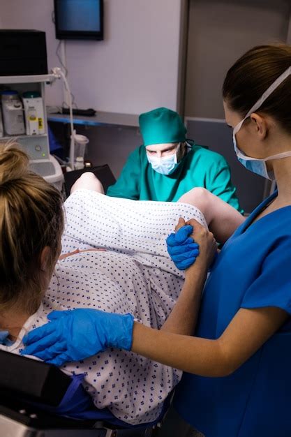 Equipo M Dico Que Examina A La Mujer Embarazada Durante El Parto Foto