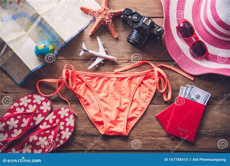 Beauty Orange Bikini And Accessories On Wooden Floor For Trip On Summer