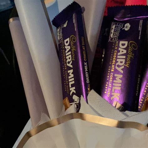 Three Bars Of Dairy Milk Are In A White Container With Gold Foil