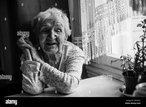 Elderly Woman Sitting In Her Home Black And White Portrait Stock Photo