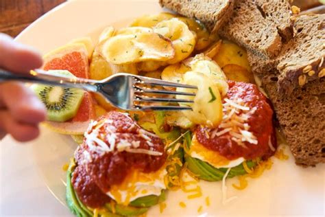 Mano Cortada De Una Persona Con Un Tenedor En El Desayuno En Un Plato