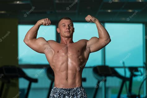 Atleta Musculoso Culturista Posar En El Gimnasio Foto Premium