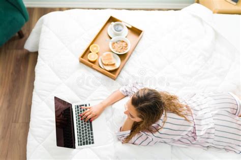 Vista Superior De Uma Mulher Latina Digitando Em Um Laptop Na Cama Foto