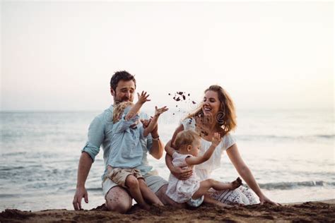 Una Familia Con Dos Ni Os Del Ni O Que Se Sientan En La Playa De La