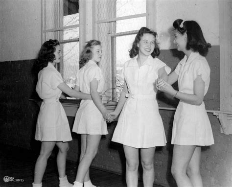 four women in short dresses are standing near a window and smiling at ...