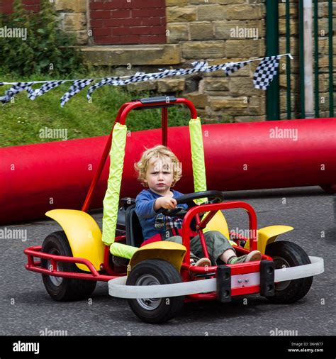 3 year old boy driving a small racing car around a track Stock Photo ...