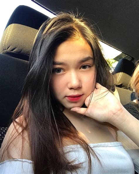 A Woman Sitting In The Back Seat Of A Car With Long Hair On Her Head