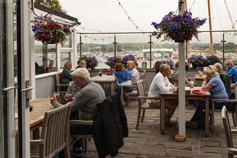 Holidaymakers In A Hotel Restaurant With A View Over The Harbour Isles