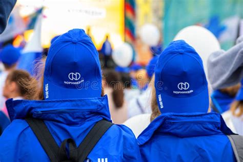 Two Students at a Demonstration in Caps with the Norilsk Nickel Logo ...