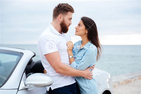 Young Beautiful Young Couple Embracing While Standing Near Car At The Seaside Royalty Free Stock