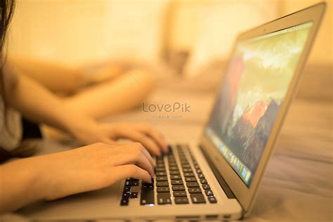 한 젊은 여자가 침대에 누워 컴퓨터 게임 사진 무료 다운로드 Lovepik