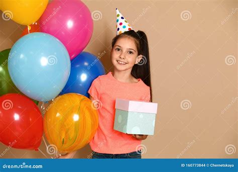 Happy Girl With Birthday T And Balloons On Brown Stock Photo Image