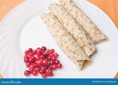 Bright Saturated Red Currant Berries And Three Pancakes Lie On A Large