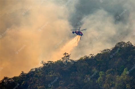 Premium Photo | Fire fighting helicopter dropping water onto wildfire