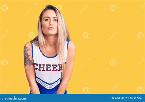 Young Beautiful Blonde Woman Wearing Cheerleader Uniform Looking At The