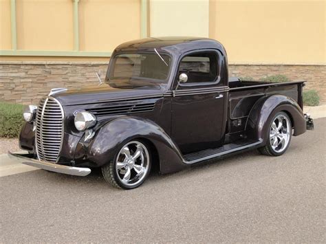 An Old Black Truck Parked In Front Of A Building