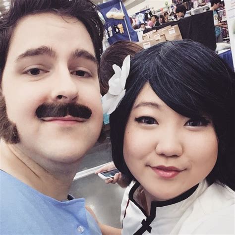 a man standing next to a woman with a moustache