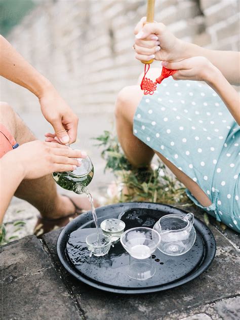 "Couple Pouring Tea On Ceremony" by Stocksy Contributor "Dreamwood Photography " - Stocksy