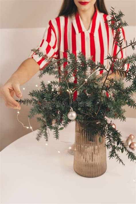 A Beautiful Girl Decorates Coniferous Branches With A New Year S