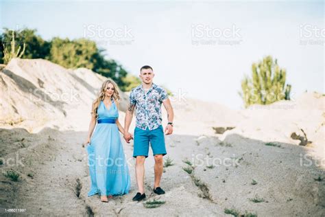 Blonde Girl In A Light Blue Dress And A Guy In A Light Shirt In A