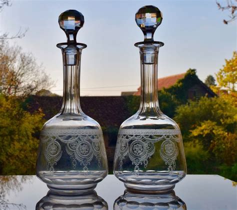 Two Glass Vases Sitting On Top Of A Table