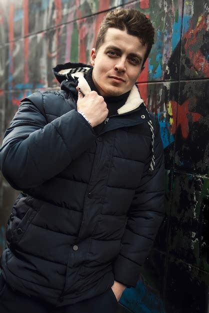 Premium Photo Attractive Confident Young Brunet Man Standing Against Colorful Graffiti Wall