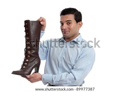 Smiling retail salesman holding or showing off a ladies leather boot. - stock photo