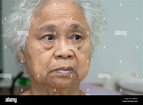 Asian elderly old woman face and eye with wrinkles, portrait closeup ...