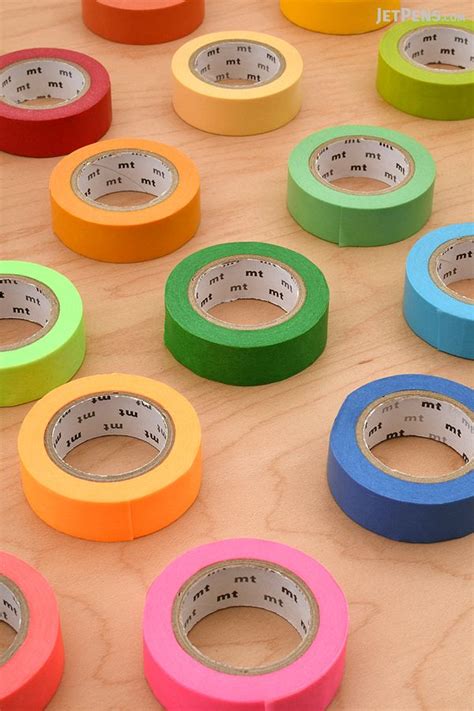 Several Rolls Of Colored Tape Sitting On Top Of A Wooden Table Next To