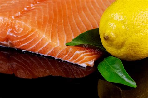 Filetto Di Pesce Di Color Salmone Crudo Su Fondo Nero Fotografia Stock